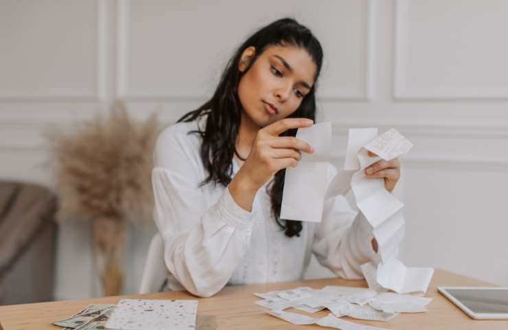 donna che legge gli scontrini della spesa